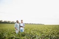 Two African and Indian farmers check the harvest in a corn field. Royalty Free Stock Photo