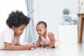 Two African kids, cute newborn 11 months baby girl and 5 years old boy, brother and sister playing together on floor, having fun Royalty Free Stock Photo