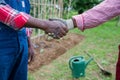 Two African peasants shake hands while working in the fields