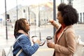 Two african woman friends drinking coffee outdoor, smiling and talking Royalty Free Stock Photo