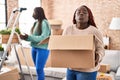 Two african women moving to a new home looking at the camera blowing a kiss being lovely and sexy Royalty Free Stock Photo