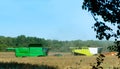 Two agricultural machines operate in the field, grain harvesting machines operate in the field, agricultural land Royalty Free Stock Photo