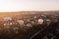 Two air balloons flying over green park and small european city at summer sunrise Royalty Free Stock Photo