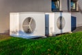 Two air source heat pumps installed outside of a modern house Royalty Free Stock Photo