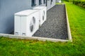 Two air source heat pumps installed outside of new and modern city house Royalty Free Stock Photo