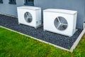 Two air source heat pumps installed outside of new and modern city house, green renewable energy concept of heat pump Royalty Free Stock Photo