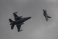 two airplanes flying in the sky while being photographed together on a cloudy day