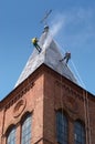 Two alpinist cleans church roof Royalty Free Stock Photo