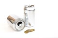 two aluminum cans and coins on a white background, the concept of getting money for aluminum