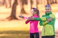 Two amateur athletes mature man and woman are warming up before jogging, doing upper body stretching in the park Royalty Free Stock Photo