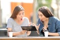 Two amazed friends watching media in a tablet