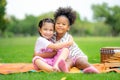 Two american african little girl as friends hug each other in cheerful way. Little girlfriends in park. Childhood, family, love,