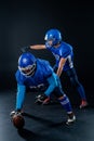 Two American football players are ready to start the game on a black background. Royalty Free Stock Photo