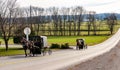 View of Two Amish Horse and Buggies Traveling Down a Countryside Road Thru Farmlands Royalty Free Stock Photo