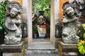 Ancient Ganesha statue visible through a temple doorway flanked by vintage stone guardian figures in Bali Indonesia