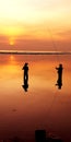 Two anglers chatting while enjoying the sunrise at Sanur beach Royalty Free Stock Photo