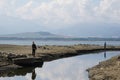 Two anglers fishing in arid or dried up small river channel supplaying water to dam Liptovska Mara. Royalty Free Stock Photo