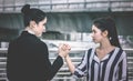 Two angry business woman arm wrestling conflict