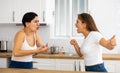 Two angry displeased Hispanic women quarreling in home kitchen Royalty Free Stock Photo