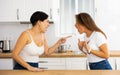 Two angry displeased Hispanic women quarreling in home kitchen Royalty Free Stock Photo