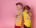 Two angry kids boy and girl. frowning brother and sister standing back to back. School children do not talking to each Royalty Free Stock Photo