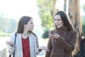 Two angry women arguing in a park in winter