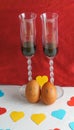 Two animated eggs with two glasses of wine and colored hearts, love concept