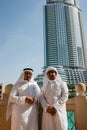 Two anonymous Arab men in traditional white clothing looking at