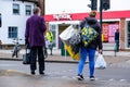 Two Anonymous Women Shoppers Waiting To Cross A Road At Pedestrian Lights