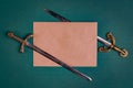 Two antique knightly swords and a sheet of old paper on a green velvet background.