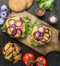 Two appetizing juicy home burger with beef, salad, pickled cucumbers, cheese and onions, tomatoes, bun with sesame ,potato ,wedges