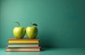 Two apples lie on stack of books against green backdrop. Symbolizes knowledge gain, autumn time. Copy space for text, Royalty Free Stock Photo