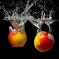 Two apples in water on a black background.red apple dropped into water with splash isolated on black Royalty Free Stock Photo