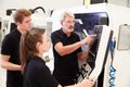 Two Apprentices Working With Engineer On CNC Machinery Royalty Free Stock Photo