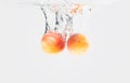 Two apricots dropped water with splash Royalty Free Stock Photo