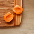 Two apricots placed on a wooden desk