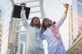 Two Arab businessmen standing by raising both hands up