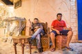 Two arabian men resting and drinking tea at night city street