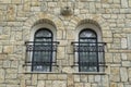 Two arched windows with black wrought iron window railings on stone wall Royalty Free Stock Photo