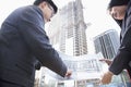 Two architects looking at blueprint at a construction site Royalty Free Stock Photo
