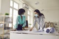 Two architects ot designers wearing face masks working on project in their office Royalty Free Stock Photo