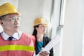 Two architects in protective workwear and hardhats working in an office building Royalty Free Stock Photo