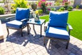 Two Arm Chairs With Blue Cushions & Small Table On Rear Patio Pavers Royalty Free Stock Photo