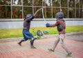 Two armed men lead a sword fight, a medieval fight, at a fun medieval tournament. Sports competitions
