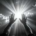 Two arms and hands reaching towards a brilliant sun with dramatic light rays in black and white Royalty Free Stock Photo
