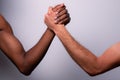 Two arms, one white caucasian and one black african, do arm wrestling, concept of diversity, racism