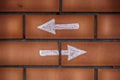 Two arrows pointing forward and backward drawn on bricks Royalty Free Stock Photo