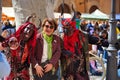Two artists dressed as scary monsters with an elderly tourist during the spring carnival