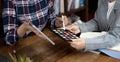 Two artists working on tablet, colour paper tone on workspace at the office