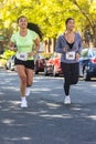 Two Asian American women run down street in 5K race